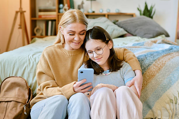 Mother and Daughter Smiling at Smartphone Together