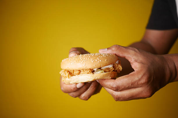 istock Delicious Handheld Fried Chicken Sandwich on Yellow Background 2207213457