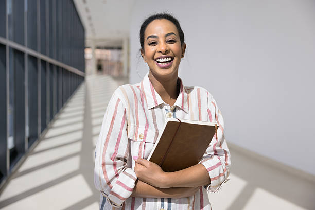 istock Cheerful African American student girl standing in spacious empty corridor 2207213898