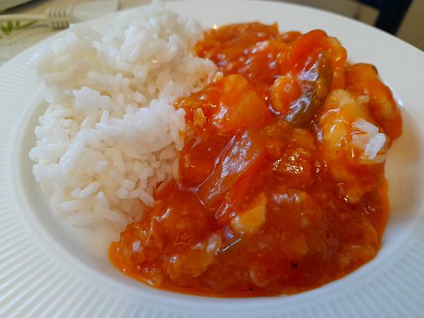 Sweet and sour chicken with steamed rice on plate