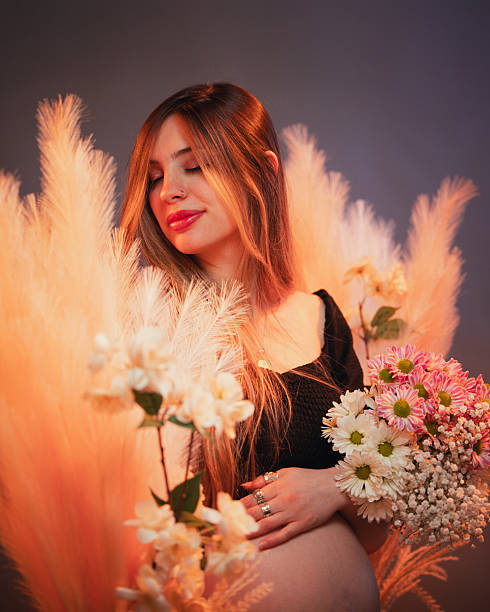 This captivating portrait features a young woman gracefully nestled amidst a vibrant bouquet of blooming flowers, blending her beauty with the delicate elegance of nature.