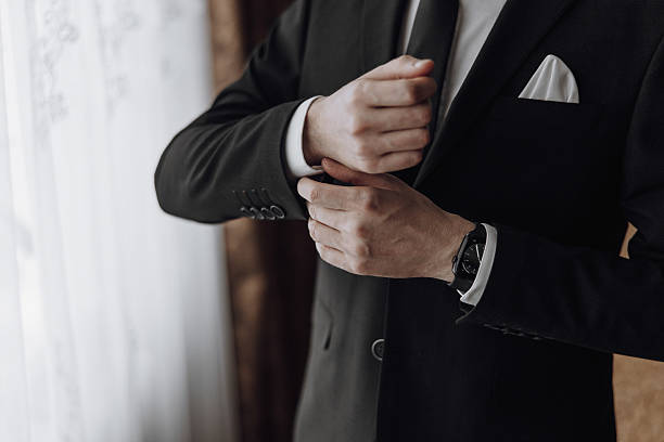 istock A man in a suit is getting ready to tie his tie 2207221047
