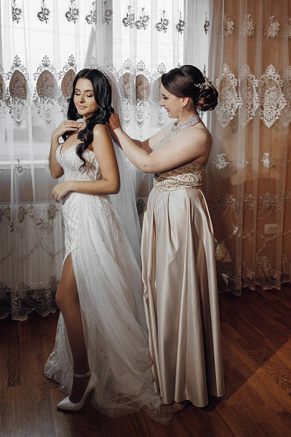 istock A bride is getting ready for her wedding with the help of her bridesmaid 2207221131