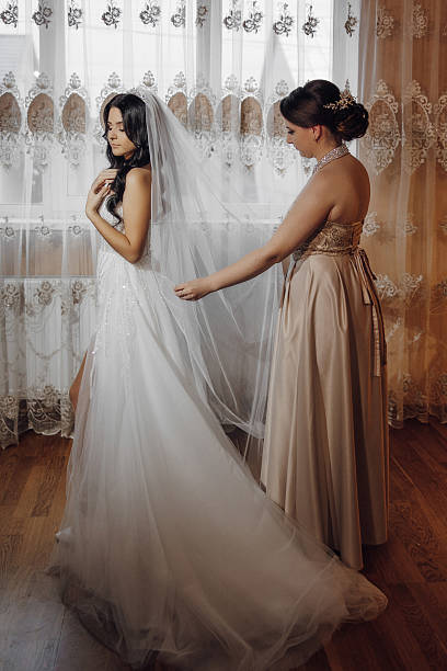 istock A bride is getting ready for her wedding with the help of her bridesmaid 2207221133