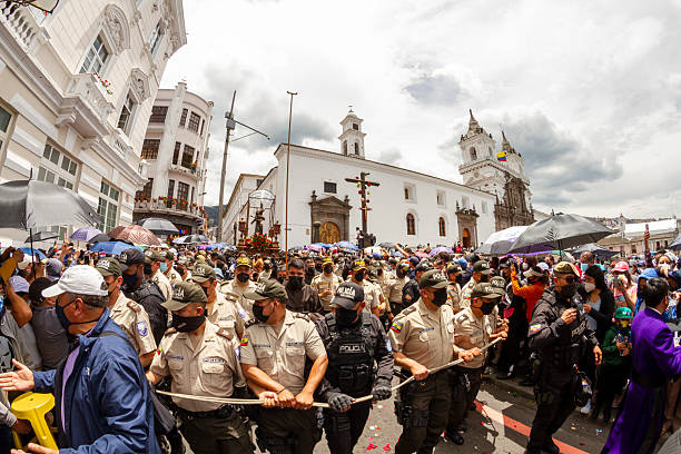 Quito, Pichincha, Ecuador - April 15, 2022: Police officers controlling the crowd with a rope during the traditional Jesus del Gran Poder Procession during Holy Week in Quito, Ecuador