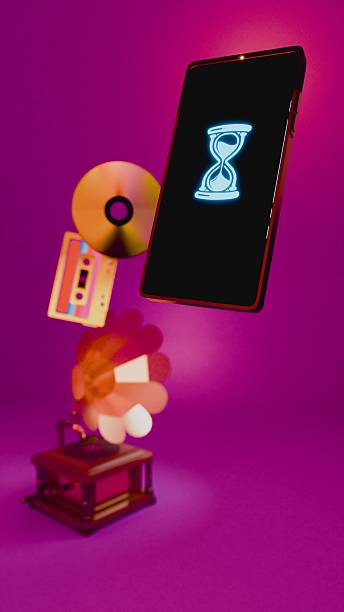 istock Smartphone with Hourglass Icon Floating Above Gramophone Cassette and CD on Purple Background 2207228584