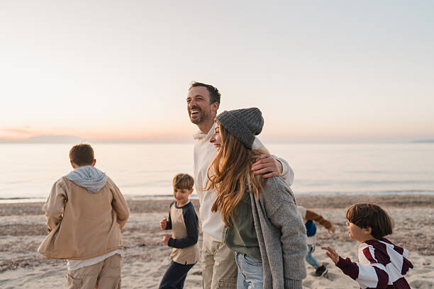 Photo of a young family, having a relaxed walk down the beach by the ocean