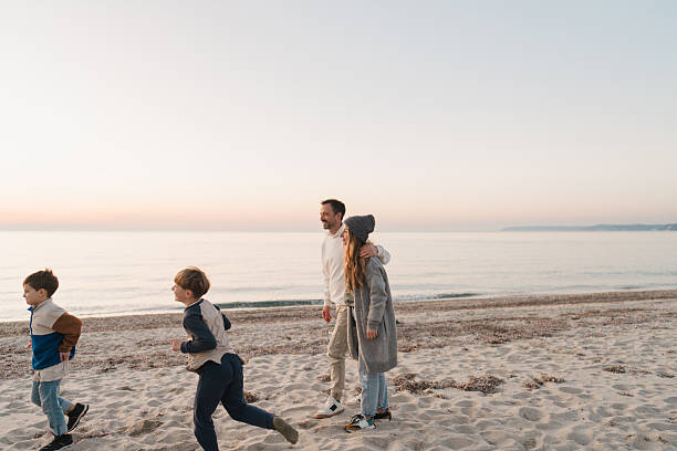 istock Family walk down the beach 2207228963