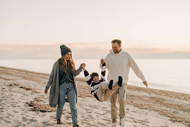 istock Family walk down the beach 2207228988