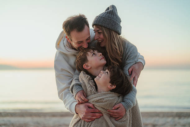 Portrait of a young family, having a picnic on the beach by the ocean