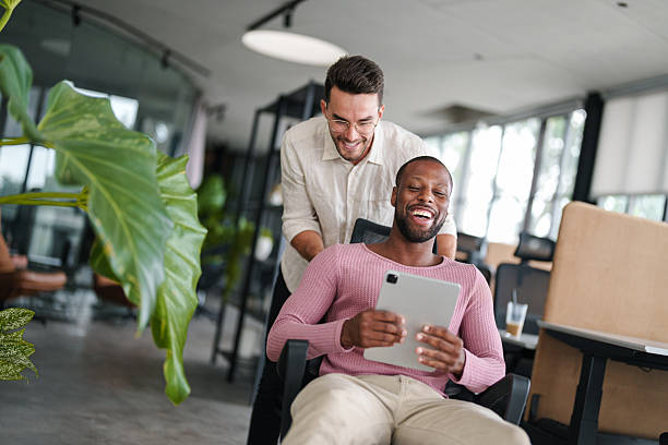 istock Young Professionals Share Laugh Over Digital Content in Modern Office 2207229086