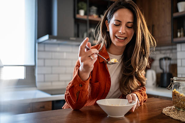 istock Young woman enjoying a healthy breakfast in her modern kitchen 2207233394