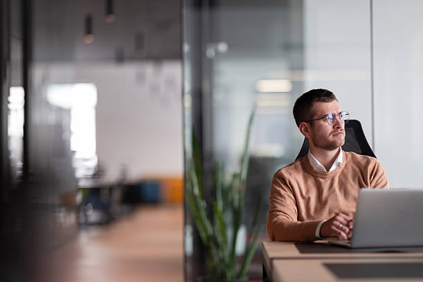 istock Businessman in glasses distracted from computer work look in distance thinking or pondering, thoughtful biracial male lost in thoughts make plans visualizing, business vision concept. 2207236406