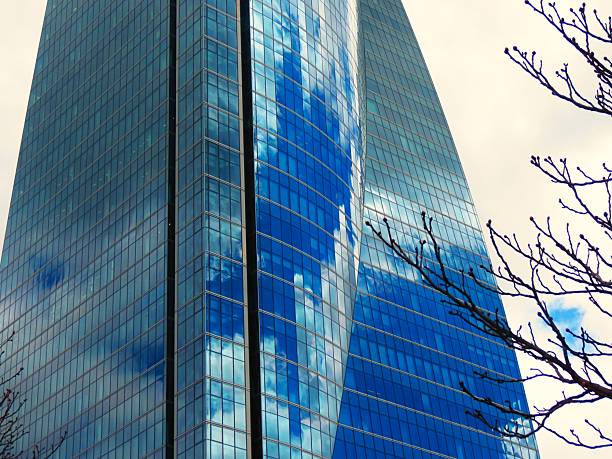 Skyscraper - glass building .Corporate Buildings. Skyscraper located in Madrid city, Spain. Interesting reflections in the glass windows of a building.Paseo de la castellana, main avenue of the city of Madrid from north to south, Spain