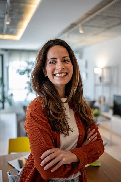 istock Young woman smiling with folded arms in modern apartment 2207240230