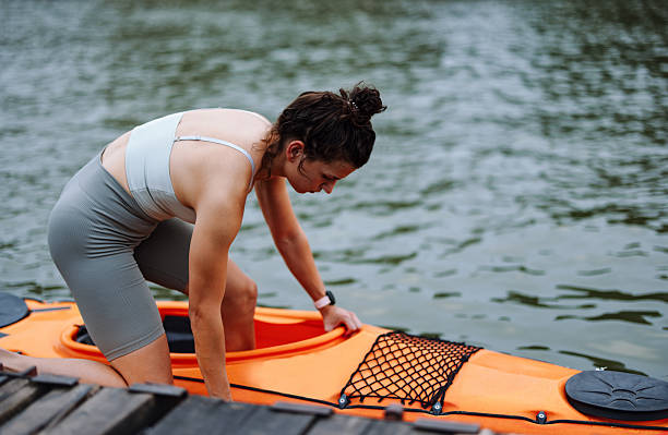 istock Woman Preparing to Kayak on a Calm River During Summer 2207242166