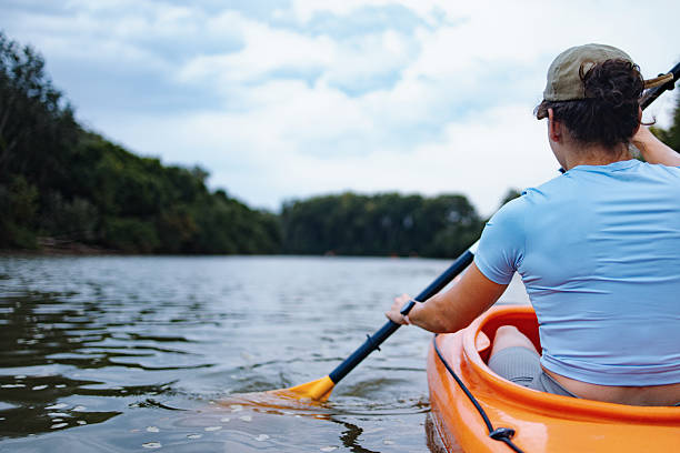 istock Person Kayaking on Tranquil River Surrounded by Lush Greenery 2207242227