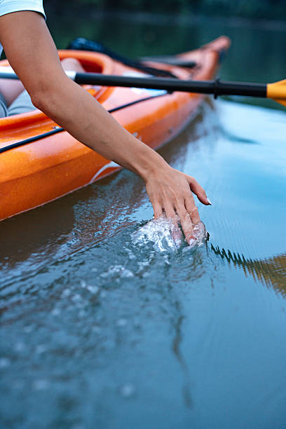 istock Close-Up of Hand Touching Water While Kayaking on Calm River 2207242241