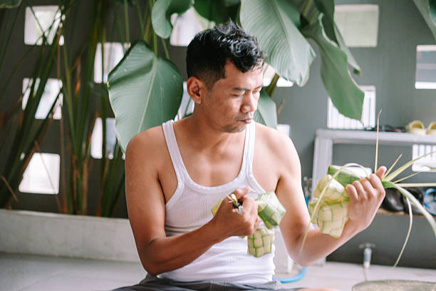 istock Crafting Ketupat, A Traditional Celebration Preparation by Southeast Asian Man 2207243130