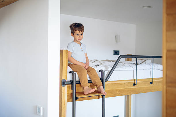 istock Little boy sitting on top of a bunk bed 2207243286