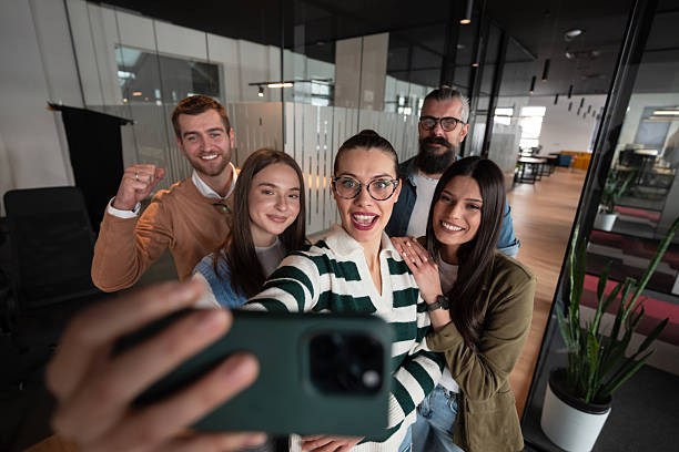 istock A diverse group of business professionals take a break from their tasks in a modern startup open space modern office to capture a creative selfie, showcasing teamwork and a vibrant workplace culture. 2207244026