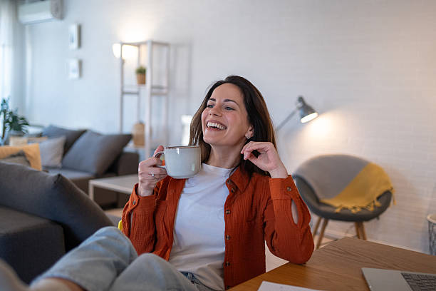 istock Happy freelancer woman drinking coffee working from home 2207244092