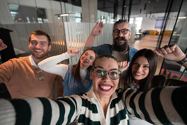 istock A diverse group of business professionals take a break from their tasks in a modern startup open space modern office to capture a creative selfie, showcasing teamwork and a vibrant workplace culture. 2207244345