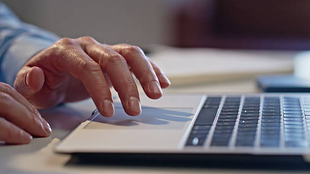 istock Man fingers swiping touchpad computer in light office closeup. Guy hands working 2207246115