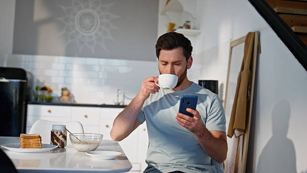 istock Relaxed brunette looking mobile phone sitting with coffee cup alone closeup 2207249971