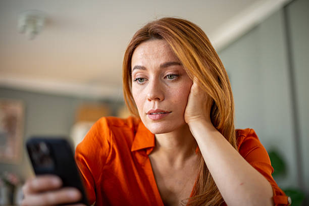 istock Woman reading a message on her phone 2207250069