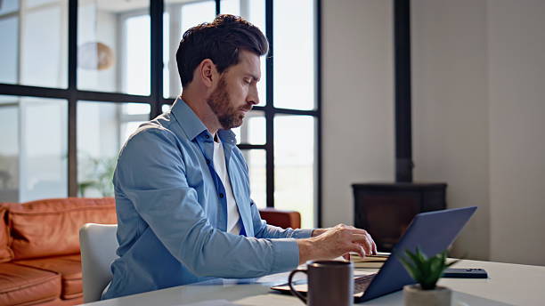 istock Bearded freelancer opening laptop lid sitting at apartment workplace closeup 2207250439