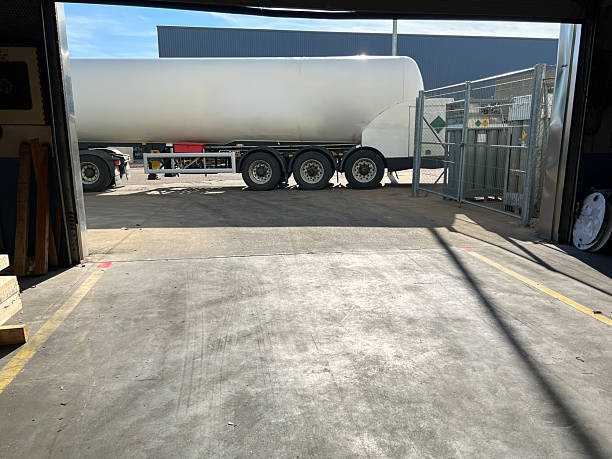 istock Tanker truck parked outside a loading dock at a factory 2207250730