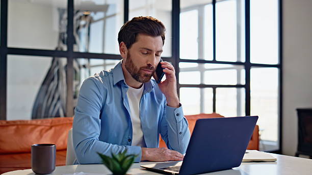 istock Smiling freelancer calling smartphone at home closeup. Relaxed man ending call 2207253013