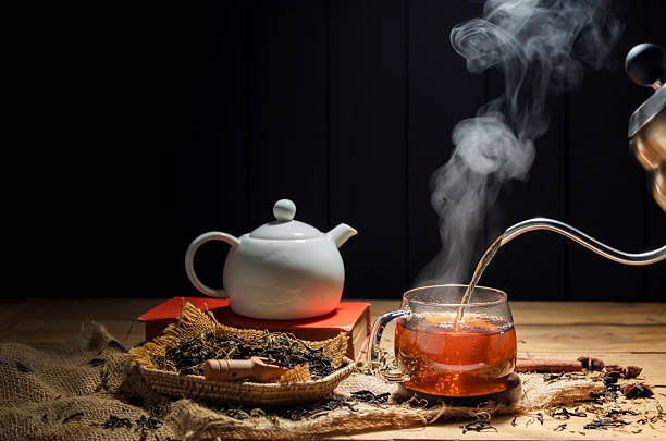 istock Pour hot tea into cups, herbal tea glasses are arranged on a rustic wooden table. 2207255219