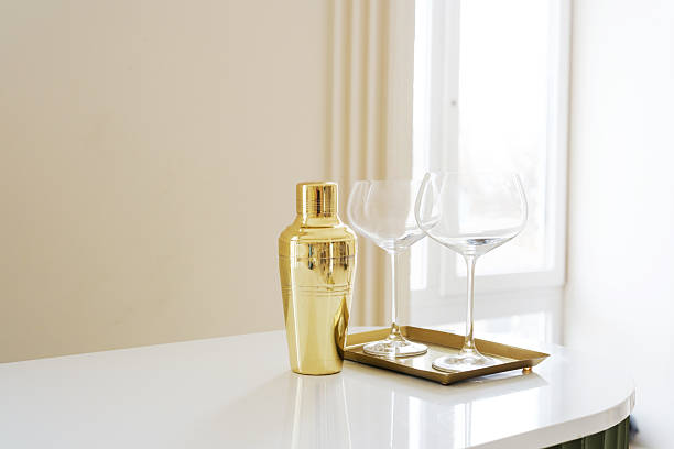 istock Golden Cocktail Shaker with Elegant Wine Glasses on White Counter 2207255564