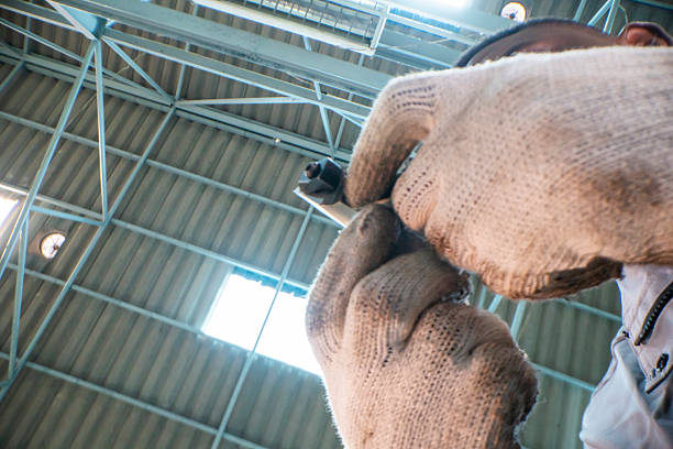 skilled worker inspects an industrial gear while holding it carefully with protective gloves. The detailed shot showcases precision, machinery, and the importance of safety in industrial environments.