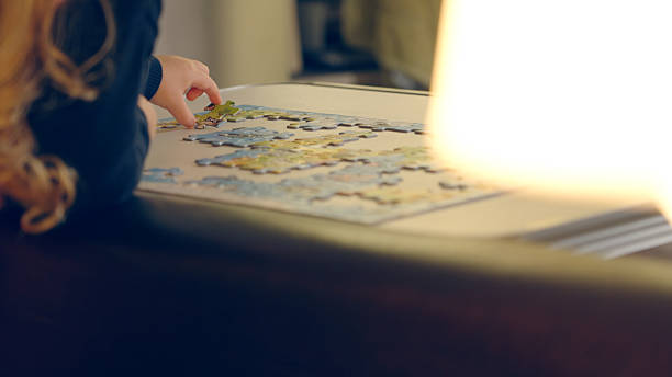 istock Child Arranging Colorful Jigsaw Puzzle In The Evening 2207255854