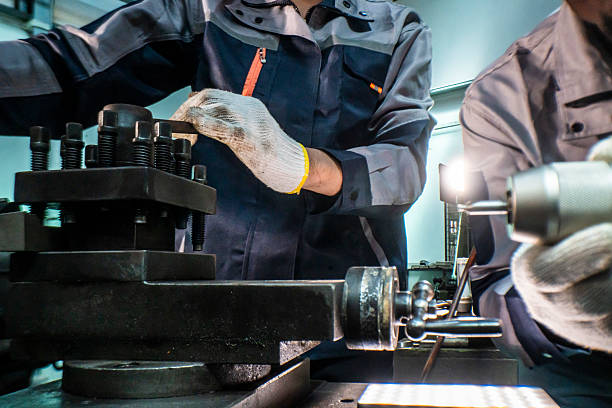 istock Two focused industrial technicians work together operating heavy machinery in a workshop. The image of teamwork, precision, and technical expertise in an engineering and manufacturing industry 2207256162