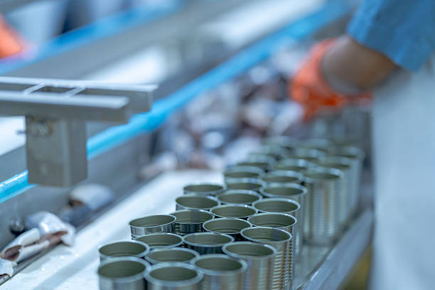 istock A food processing supervisor in protective gear inspecting packaging materials in a factory, holding a clipboard, emphasizing quality control, hygiene, and safety in food production operations 2207259688
