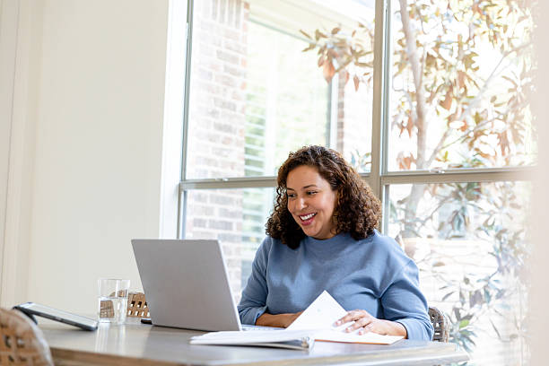 istock Smiling woman using laptop, working from home office 2207267143