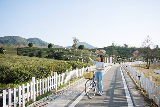 asian female selfie with smart phone while outding with bike