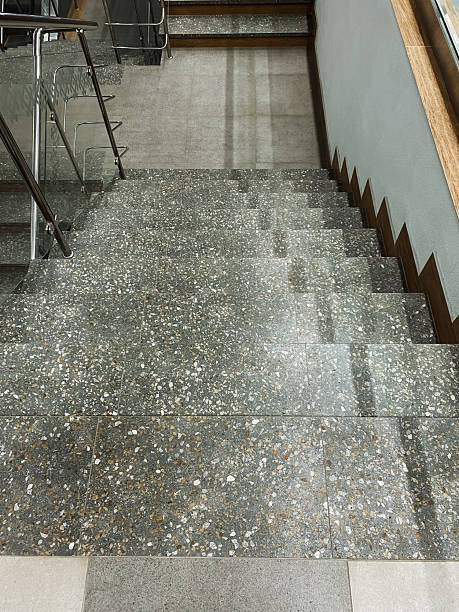 istock A beautifully designed set of stairs that features a modern glass railing along its sides, complemented by a stylish tiled floor, creating an elegant aesthetic for any space 2207275183