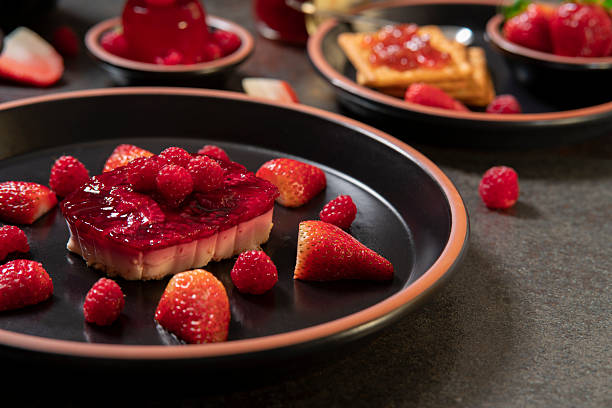 istock strawberry dessert with raspberries on a black ceramic plate in the foreground against a background of cookies with strawberry jam and strawberry jelly on a black table 2207276492