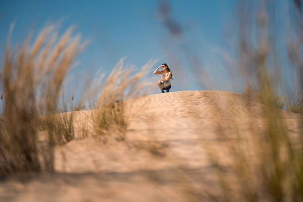 Young man uses mobile phone on wild beach