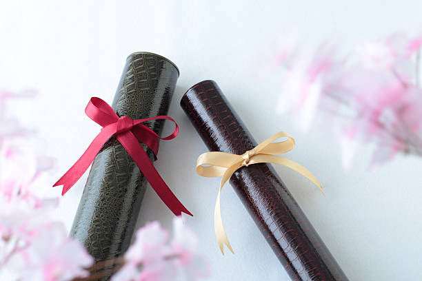 istock Graduation certificate and cherry blossom petals 2207288864