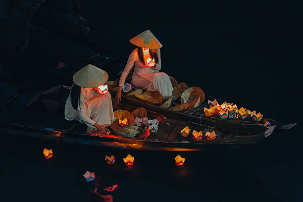 istock Traditional multicolored paper lanterns with candles floating down the river at night and beautiful woman with Vietnam culture traditional 2207289302