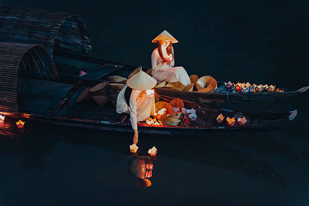 istock Traditional multicolored paper lanterns with candles floating down the river at night and beautiful woman with Vietnam culture traditional 2207289326