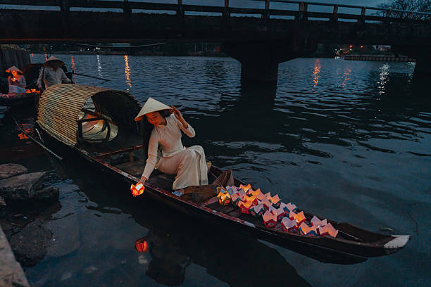 istock Traditional multicolored paper lanterns with candles floating down the river at night and beautiful woman with Vietnam culture traditional 2207289783