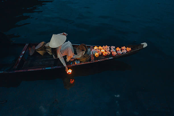 istock Traditional multicolored paper lanterns with candles floating down the river at night and beautiful woman with Vietnam culture traditional 2207289879