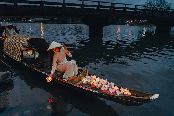 istock Traditional multicolored paper lanterns with candles floating down the river at night and beautiful woman with Vietnam culture traditional 2207289880
